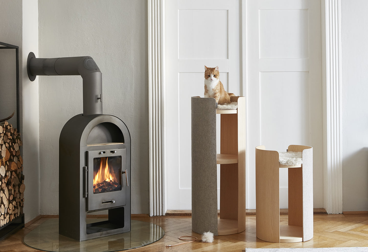 Cute cat sitting on modern Miacara cat tower and stylish scratching post.