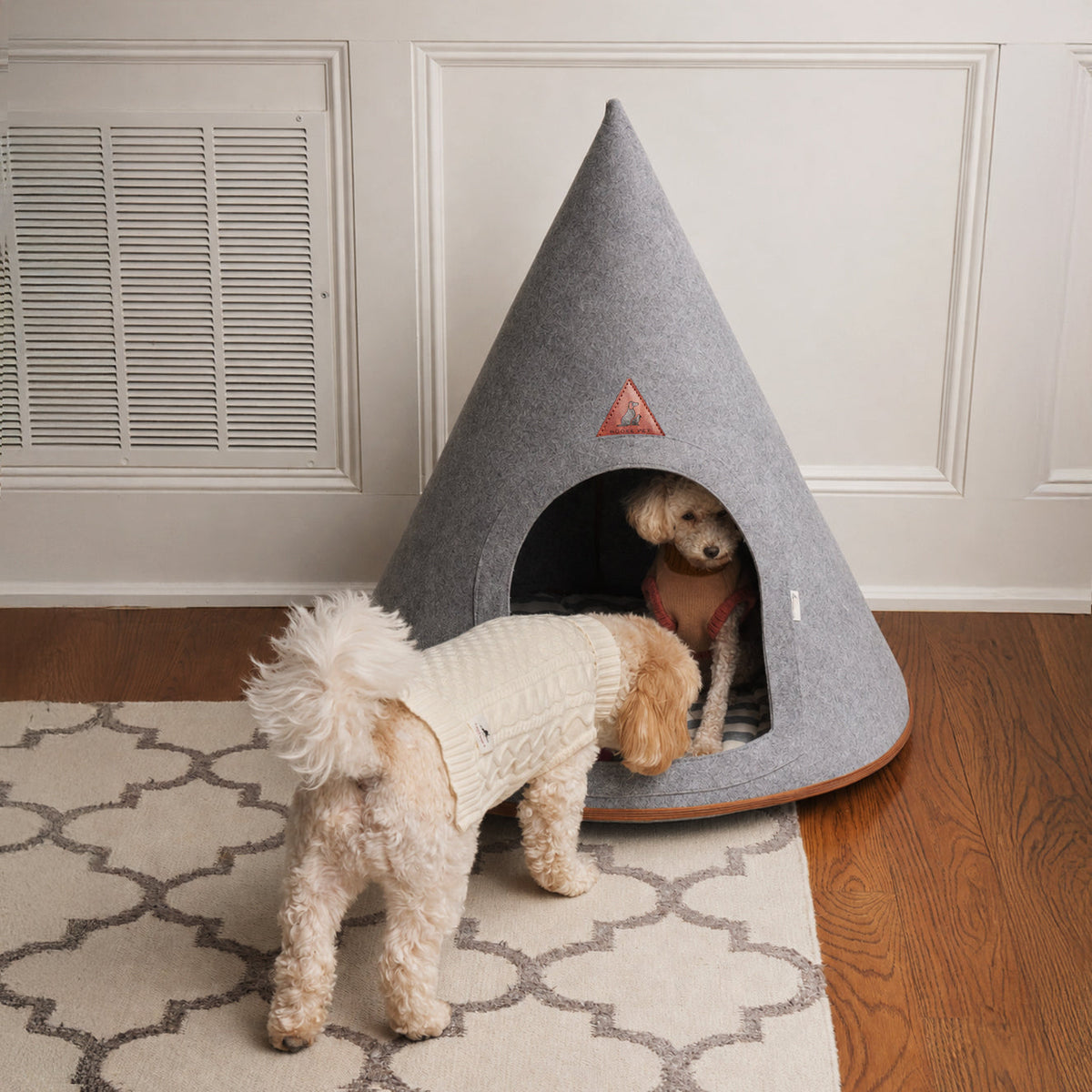 Small white dog peeking into the Nooee Pet Cave Harry XXL in gray in a living room