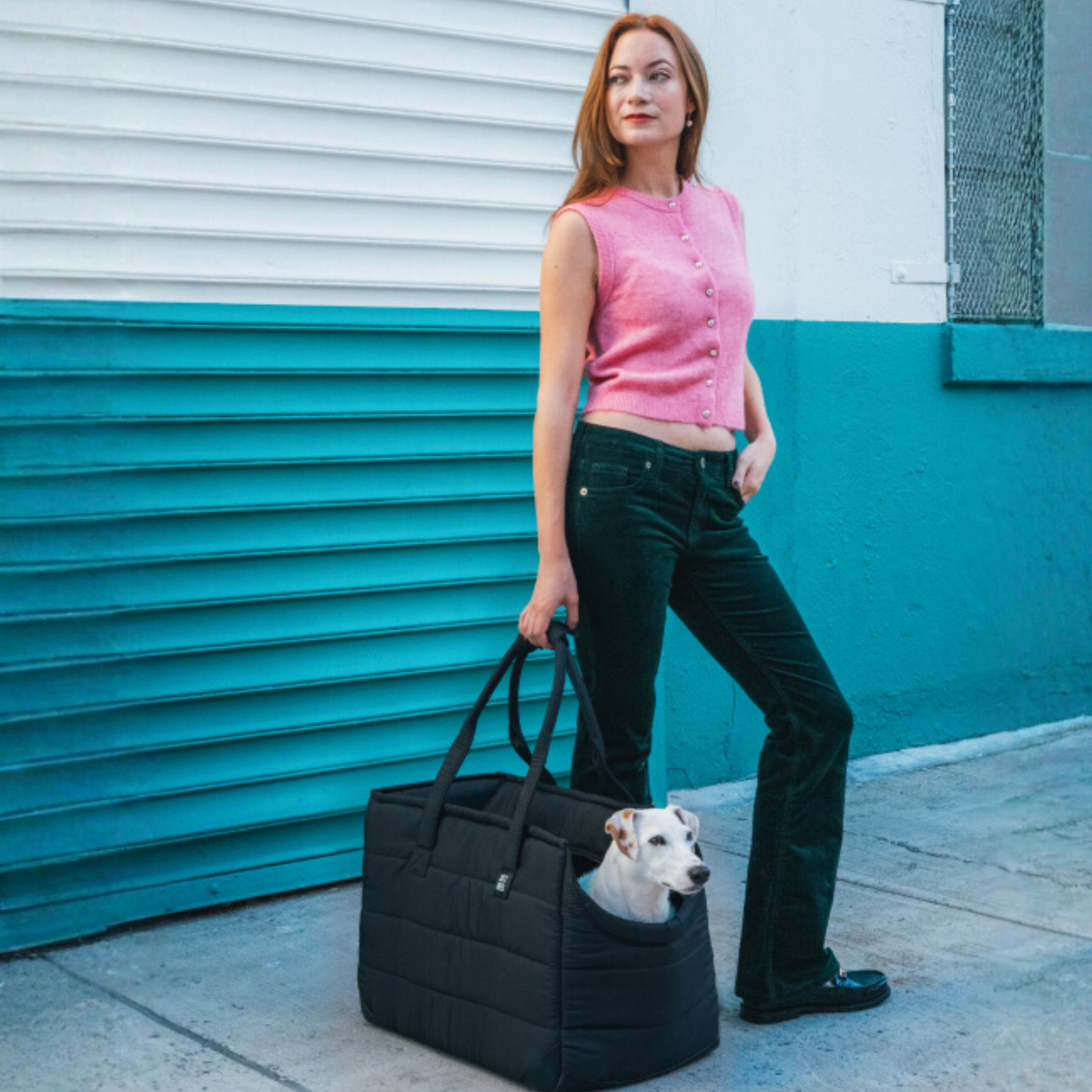 Woman on a city street with a dog peeking out of the large Subway Tote