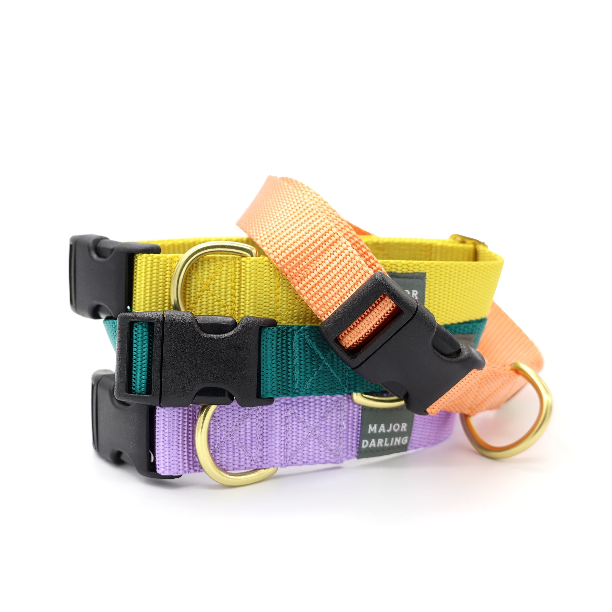 A collection of colorful dog collars with side-release buckles, featuring brass hardware and a label that reads 'MAJOR DARLING'.