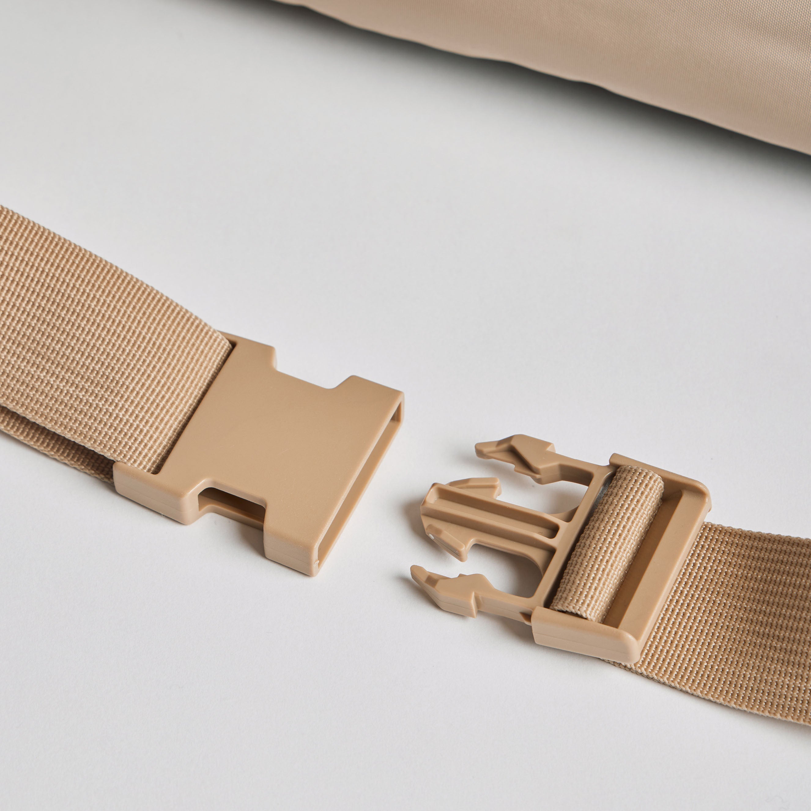 Beige belt with a unique buckle design on a light gray background