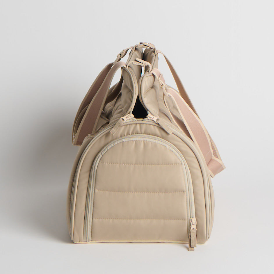 Beige pet carrier with a quilted design on a light gray background