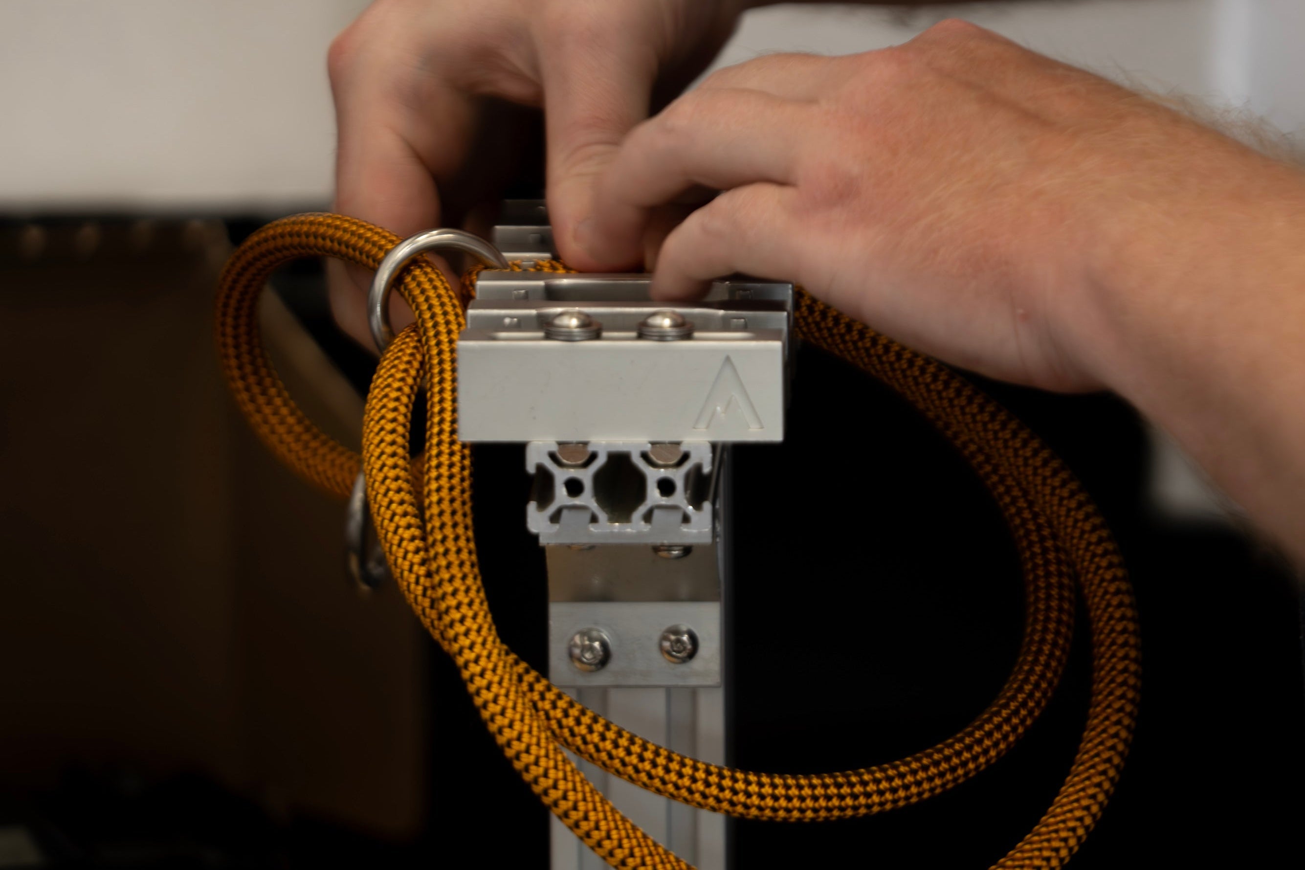 Close-up of hands adjusting a metal component with orange slip dog collar for leash training
