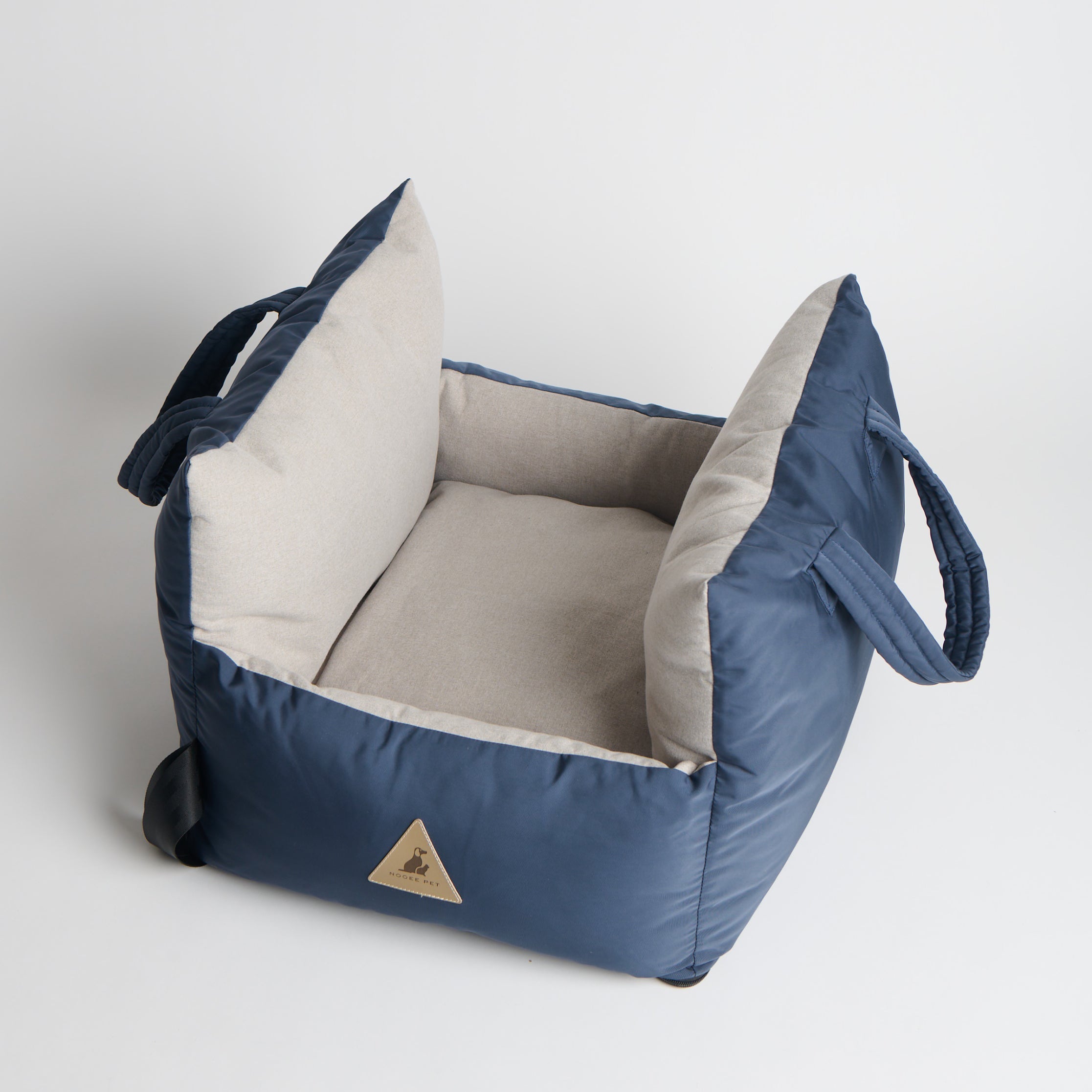Blue pet bed with beige interior on a light gray background
