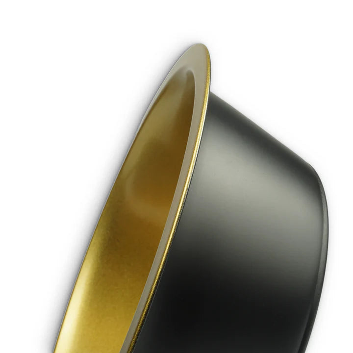 Close-up of a black and gold dog bowl on a white background