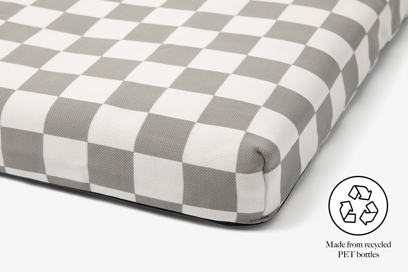 Gray and white checkered mattress cover with a recycling symbol and text on a white background