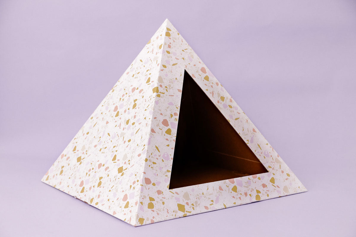Triangular pyramid-shaped cardboard box with terrazzo pattern as a cat house