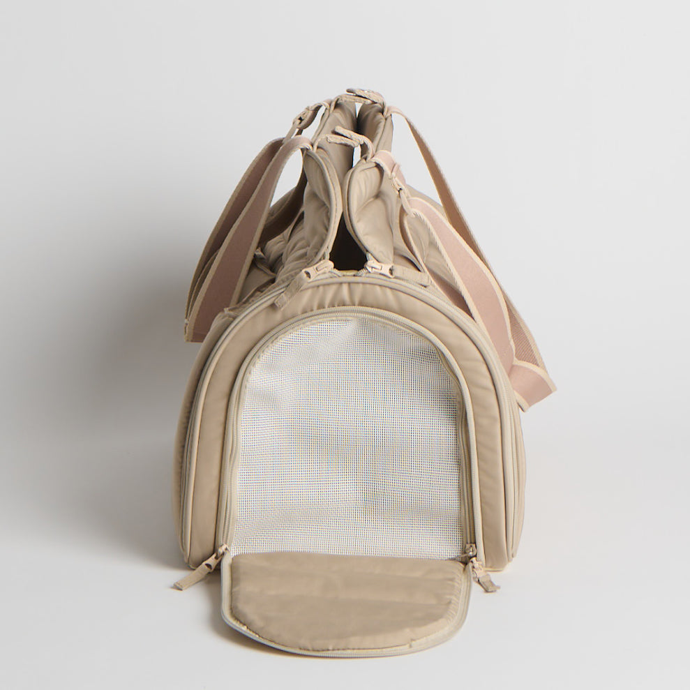 Beige pet carrier with mesh front on a light gray background
