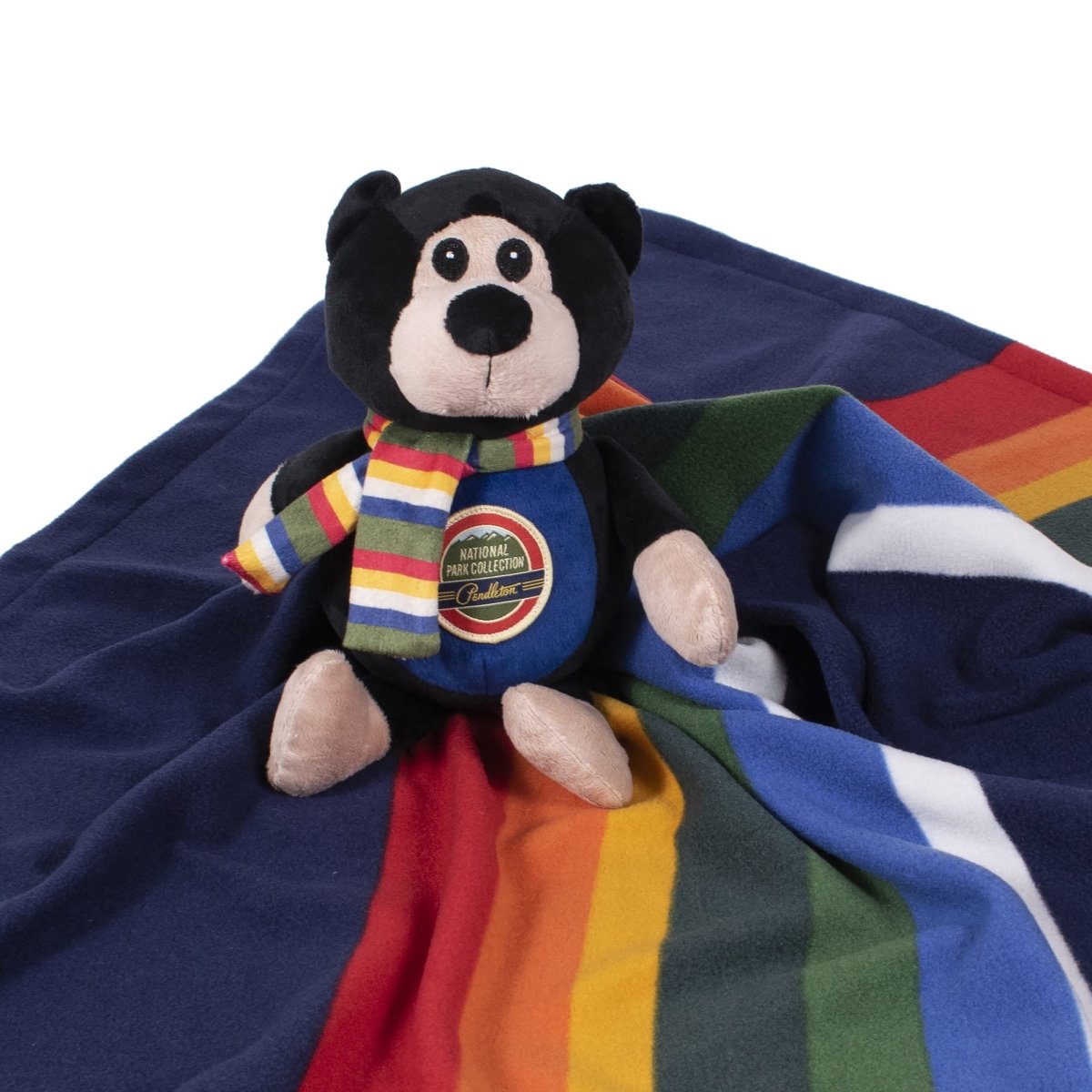 Pendleton plush bear dog toy sitting on a striped National Park blanket