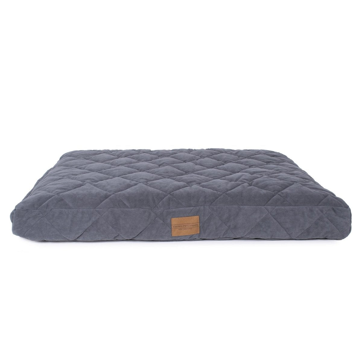 Gray quilted pet bed with a brown label on a white background