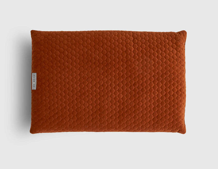 Quilted brown dog pillow on a light gray background