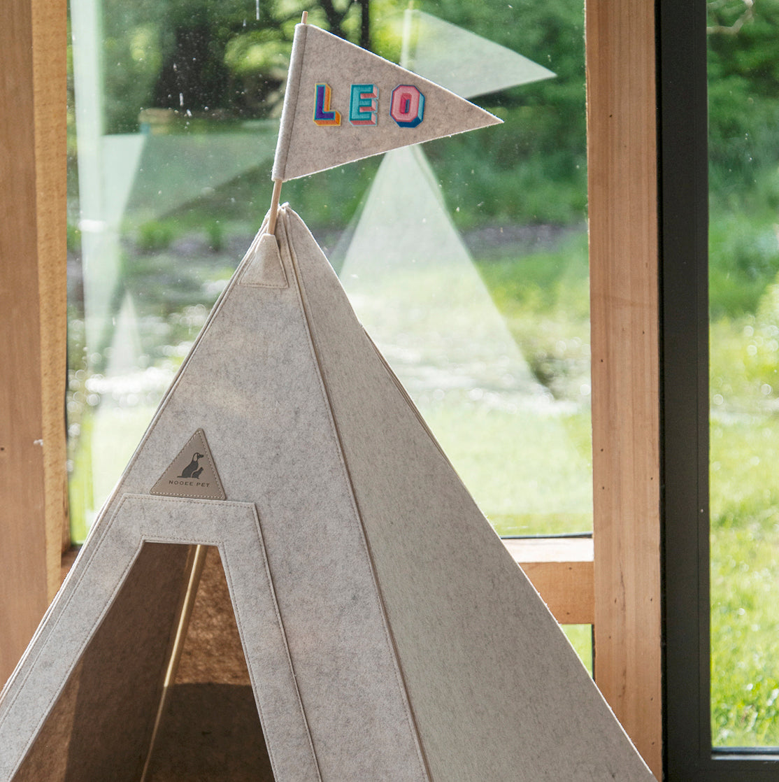 Nooee teepee pet bed with a personalized name flag by a sunny window