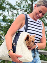 Fashionable girl carrying her dog in stylish bowsers dog carrier bag