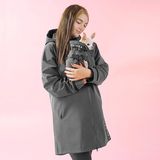 Dog owner wearing Paikka rain jacket holding her dog with matching Paikka rain jacket