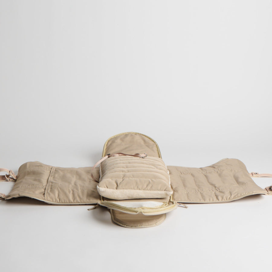 Beige backpack with quilted design on a light gray background