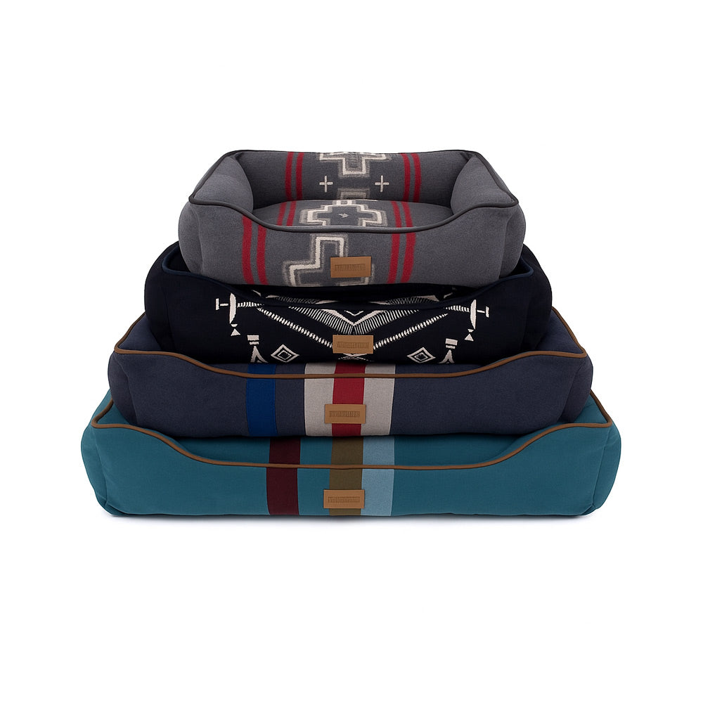 Stack of three Pendleton patterned  bolster pet beds on a white background