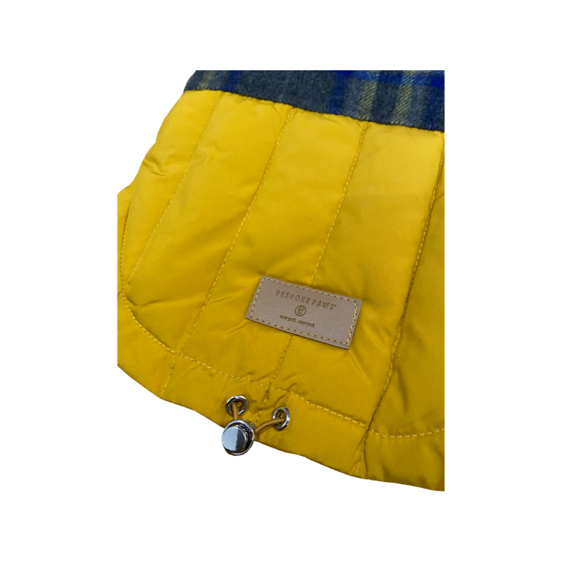 Yellow quilted dog jacket with a brand label on a white background