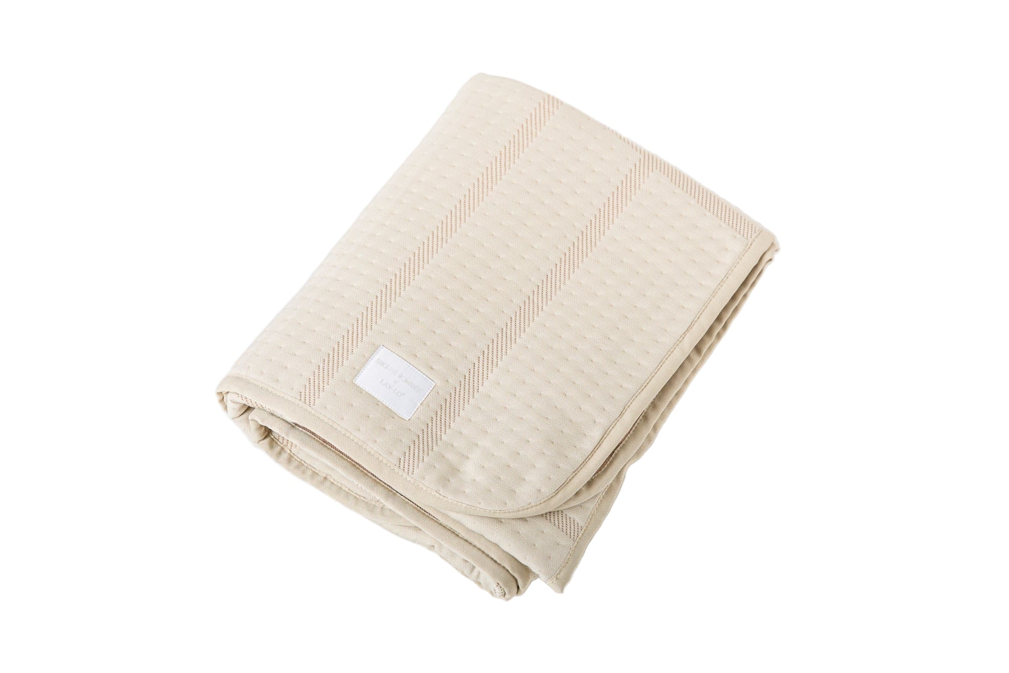Beige folded dog blanket with a brigette romanek label on a white background