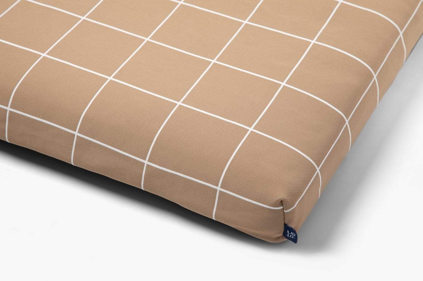 Brown dog mattress cover with white grid pattern on a gray background and lay lo brand