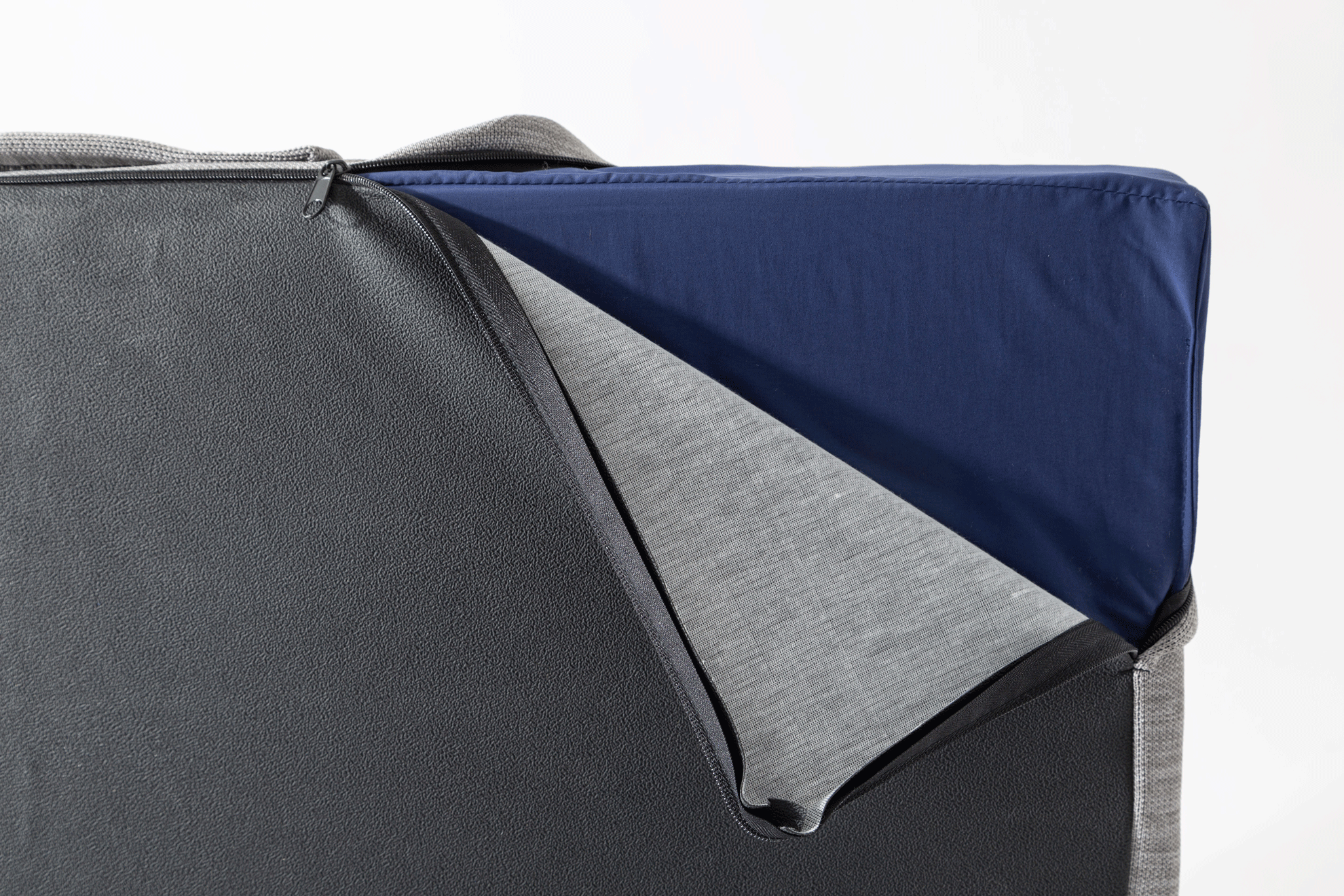 Gray and blue fabric corner with a visible seam on a white background