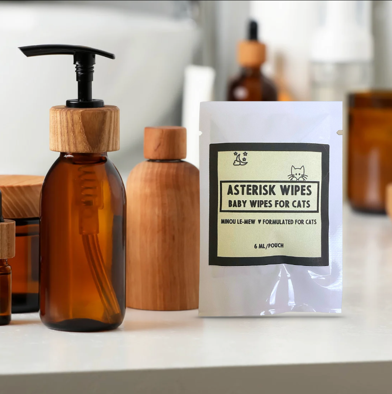 Asterisk wipes for cats packaging with brown bottles on a white surface