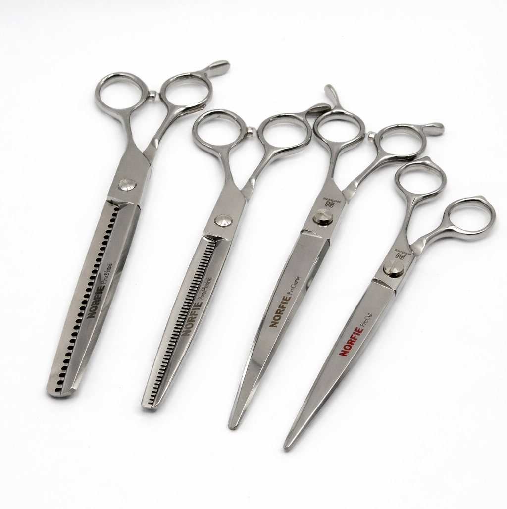 Set of four pairs of Norfie Pro Series scissors for professional dog grooming, on a white background