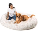 Girl sitting with her golden retriever on extra large human size dog bed in beige color