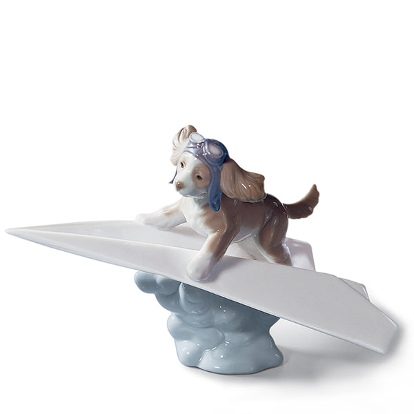 A puppy figurine on a paper airplane figurine by Lladro Porcelain